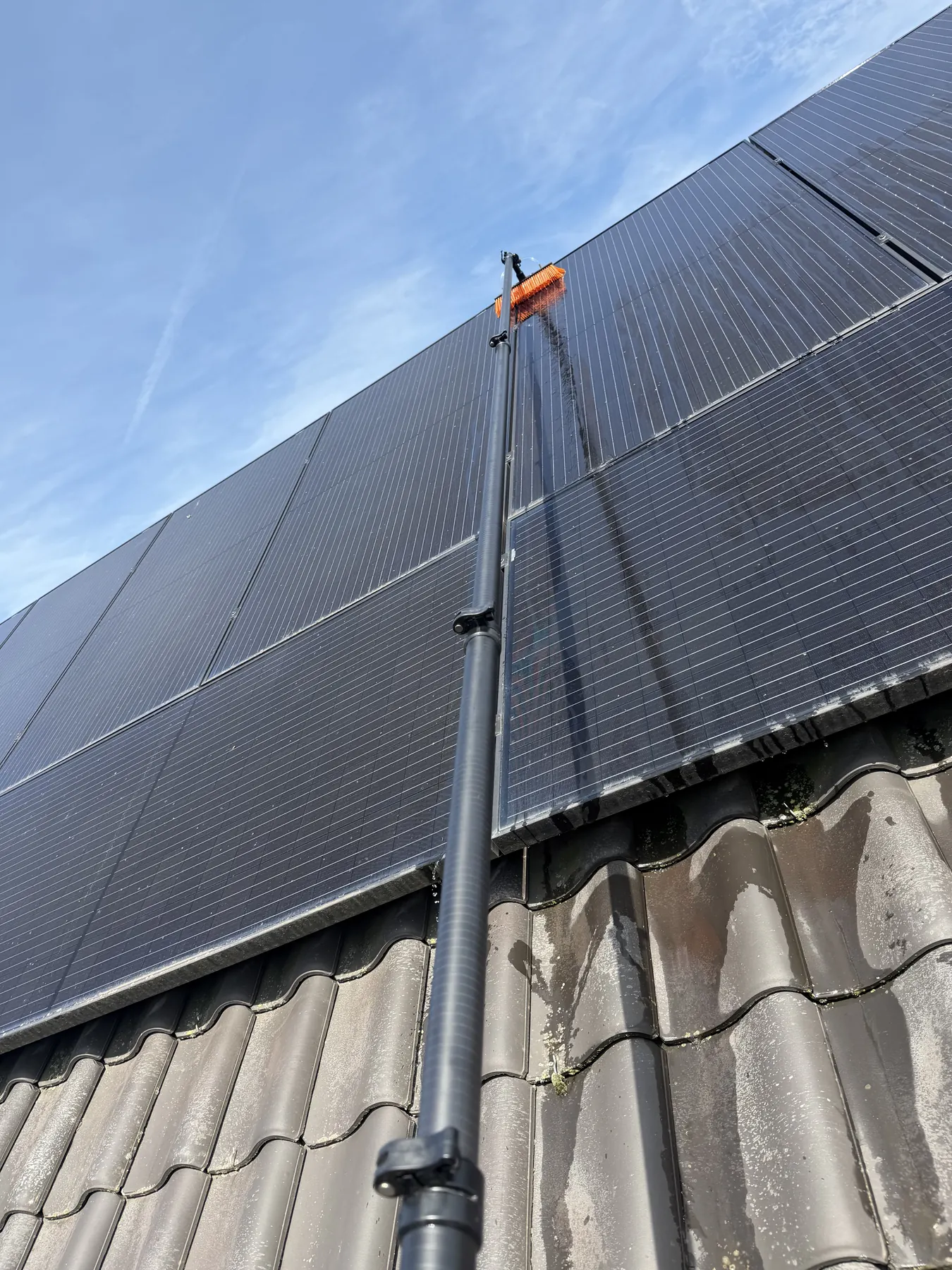 Professionele reiniging van zonnepanelen op een hellend dak